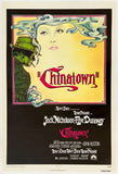 A vintage movie poster for the film "Chinatown" fills the frame. The top portion shows an illustrated woman's face with flowing blue-gray hair and a green hat on the left, with the title "Chinatown" in large red script on a pale yellow background.